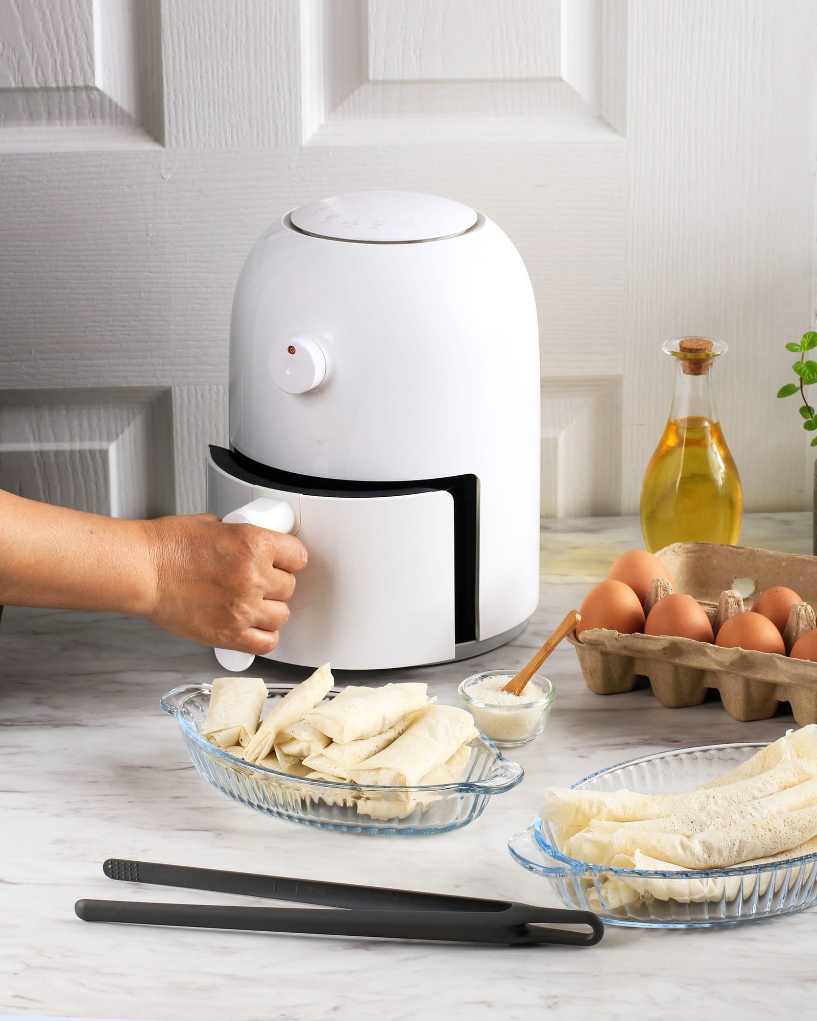 Cooking Process Using White Mini Air Fryer in the Kitchen.