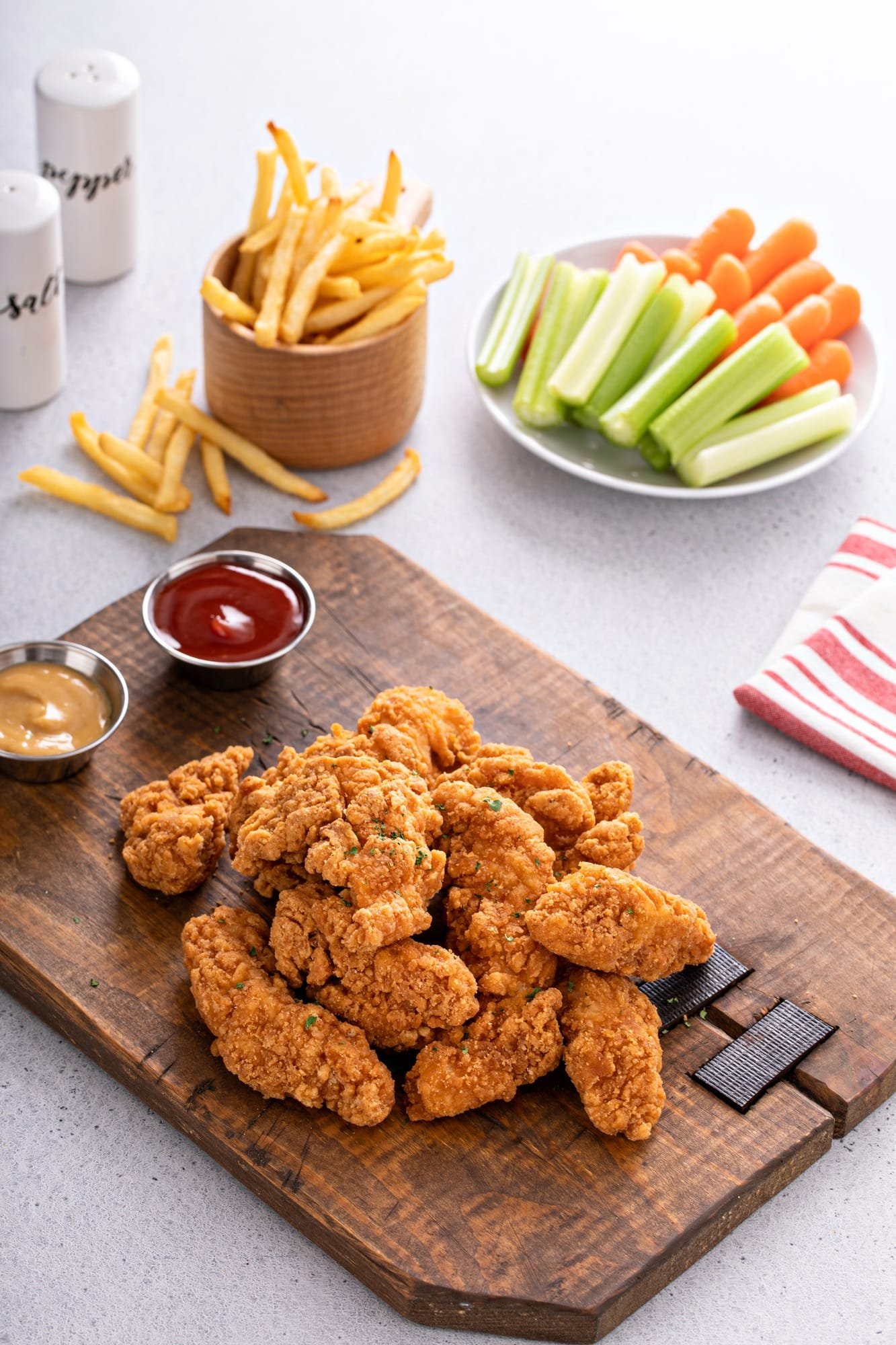 Fried chicken tenders or strips with sauces and fries