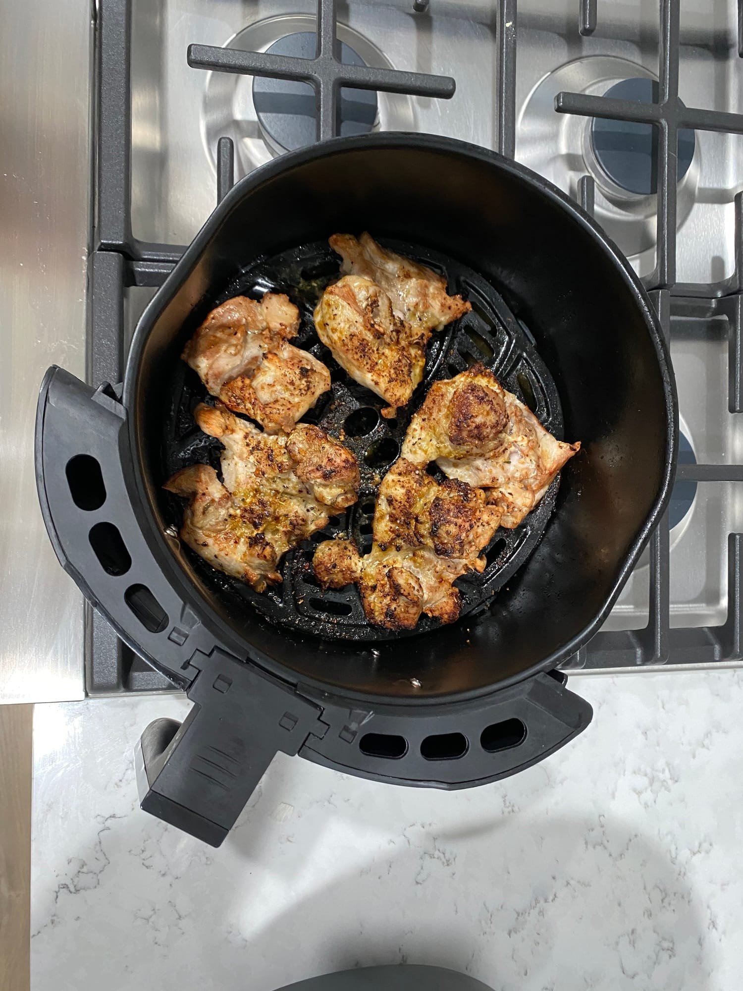 Perfectly cooked air fryer thighs come out of the air fryer